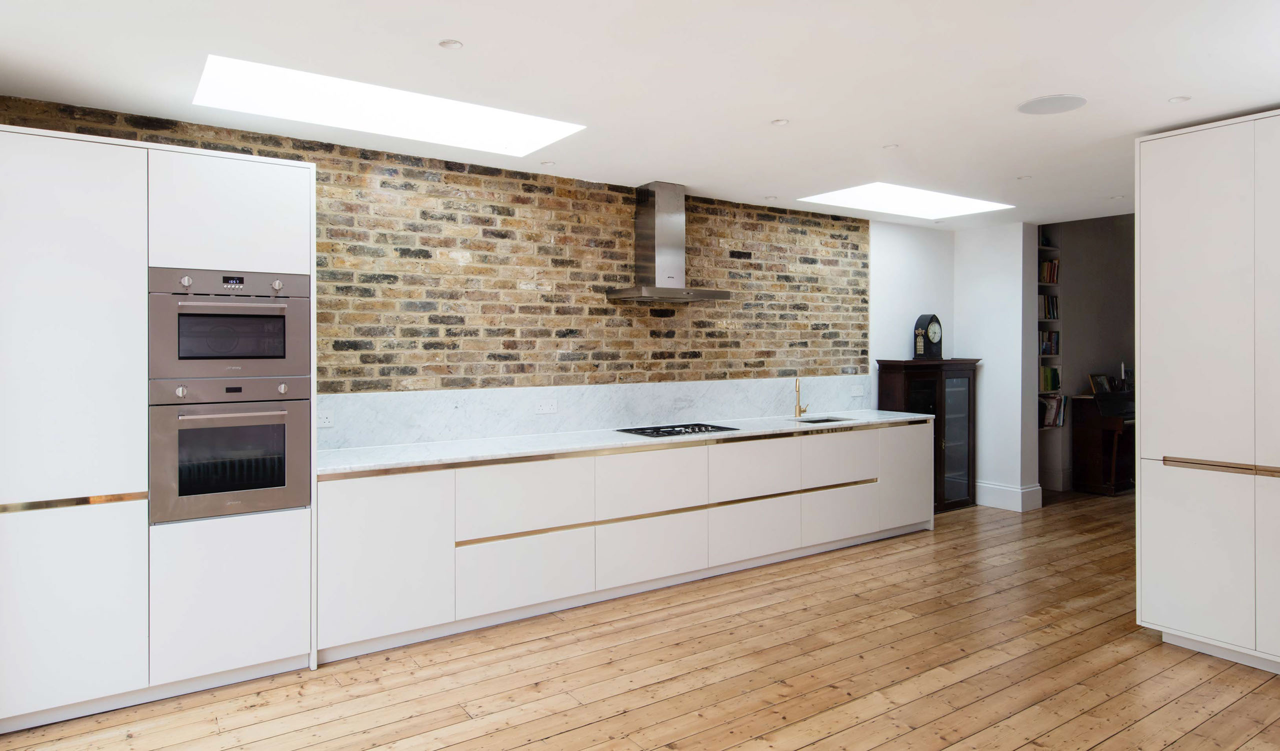 White corian kitchen with marble tops and brass